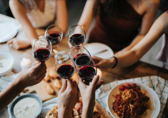 Friends toasting with wine at Courtyard Kitchen, Santa Monica