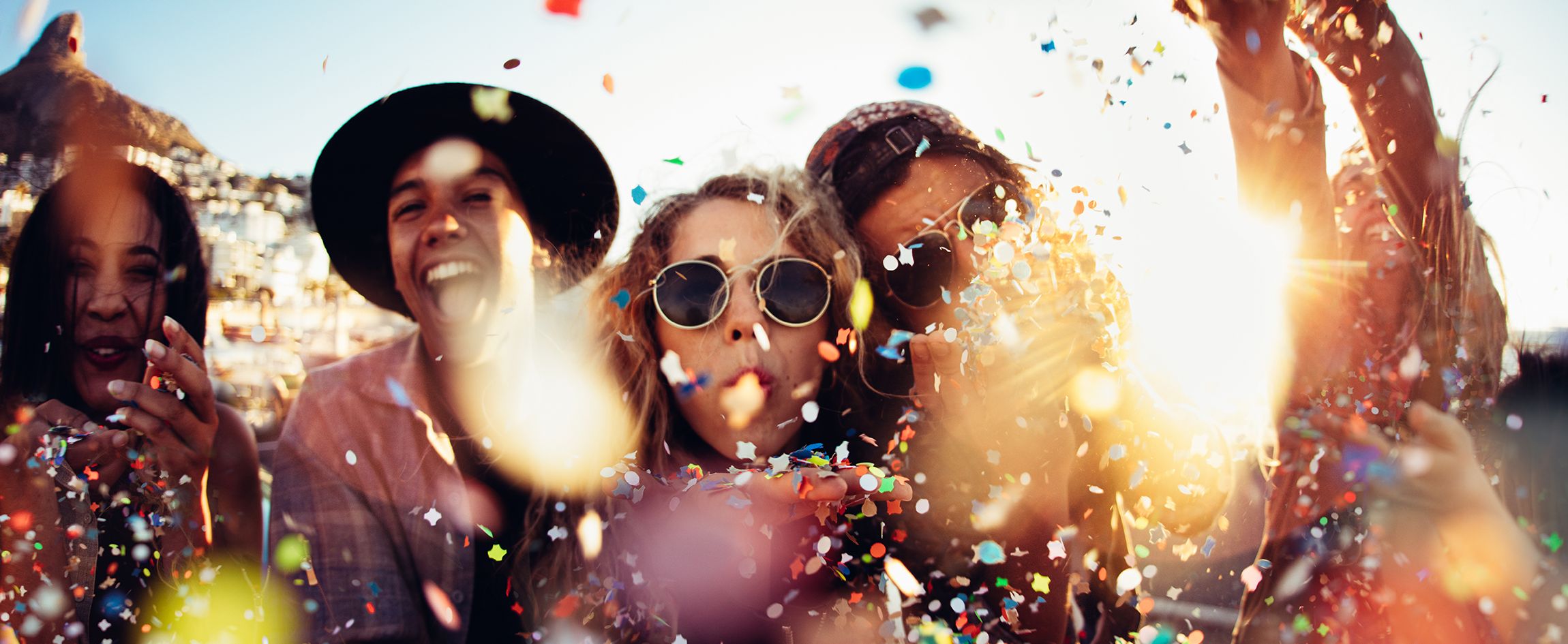 A group of friends celebrating outdoors with confetti