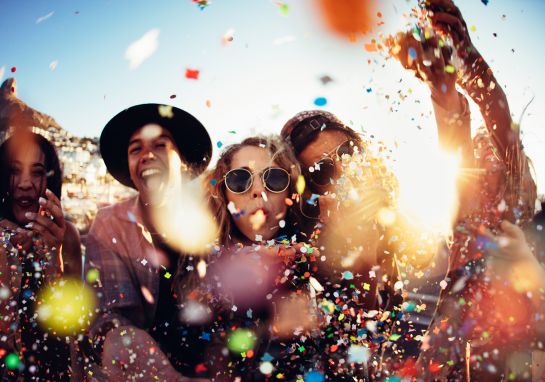 A group of friends celebrating outdoors with confetti
