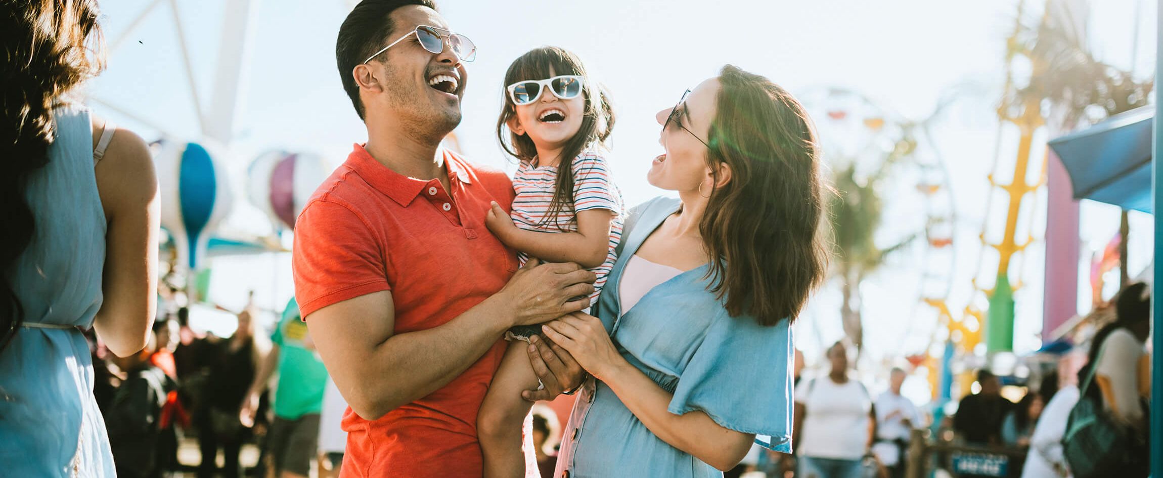 Family Laughing in front of amusement parkrides