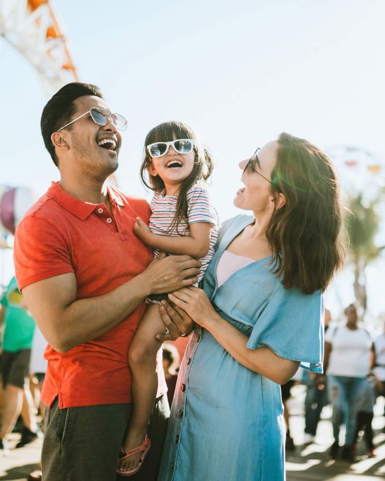 Family Laughing in front of amusement parkrides