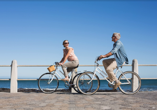 A couple riding bikes along the ocean on a Pedal... or Not Electric Bicycle Tour