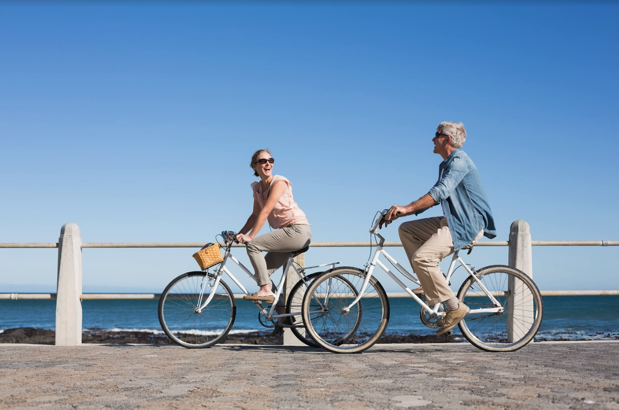 A couple riding bikes along the ocean on a Pedal... or Not Electric Bicycle Tour
