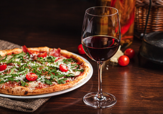 A pizza and glass of red wine from Stella Barra Pizzeria & Wine Bar
