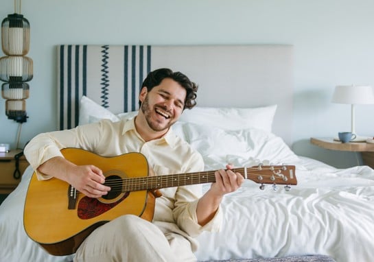 Man playing a guitar in the room borrowed from the Board Shop